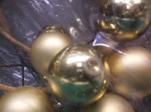 Gold christmas ball wreath has some dented balls