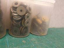 7 small jars of assorted clock parts
