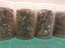 7 small jars of assorted clock parts