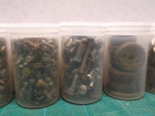 7 small jars of assorted clock parts
