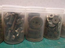 7 small jars of assorted clock parts