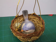 small fake blue bird and nest with green egg