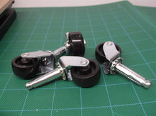 lot of 4 1-1/8" black casters with 25/64" diameter stems